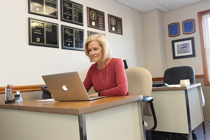 In Photo: Kim McGovern (REALTOR® Associate) adding the final details for a house closing.